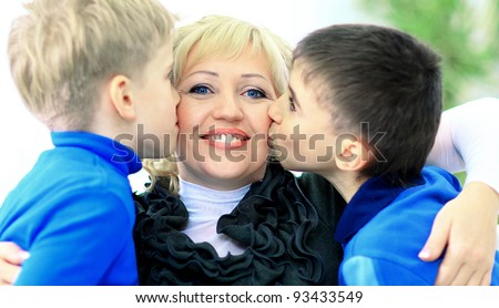 sons Giving Mother Kiss Relaxing On Sofa