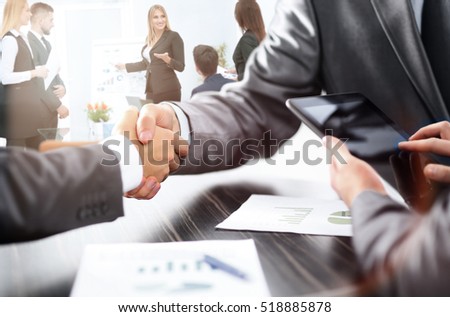 handshake of business partners after discussion of the financial