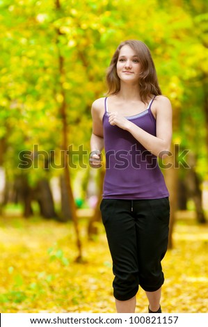 Young woman running outdoors on a lovely sunny winter (fall) day