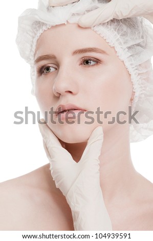 Medical examination face of beautiful woman by hands in glove - close-up portrait isolated on white