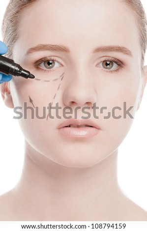 Beautician touch and draw correction lines on woman face. Before plastic surgery operetion. Isolated on white