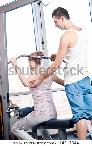 Gym man and woman doing exercise at the fitness club. Personal trainer.