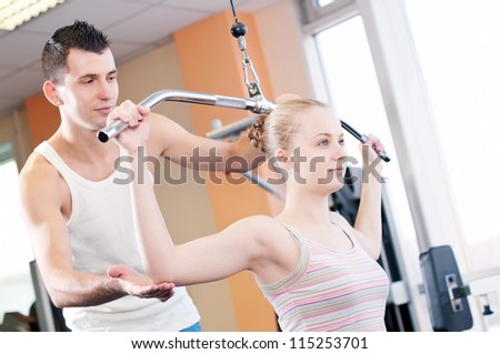 Gym man and woman doing exercise at the fitness club. Personal trainer.