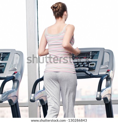 Young woman at the gym exercising. Run on a machine
