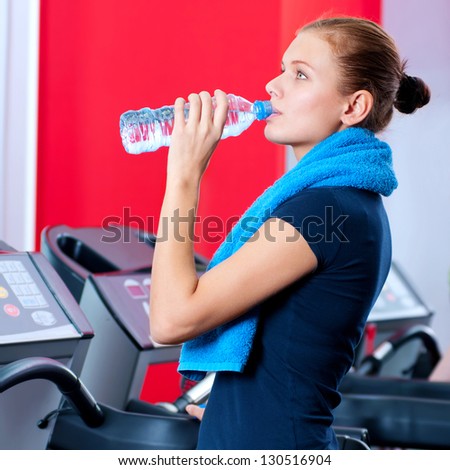 Portrait of a woman at the gym drinking water