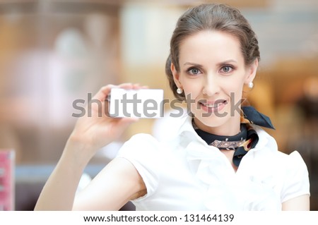 Businesswoman showing and handing a blank business card. Office background.