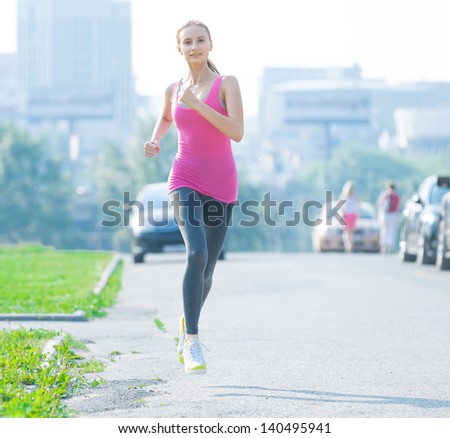 Jogging woman running in city park in sunshine on beautiful summer day. Sport fitness model caucasian ethnicity training outdoor for marathon.