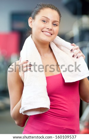 Young woman drinking water after sports. Fitness gym.