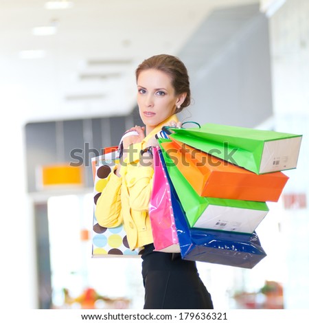 Happy woman with shopping bags in mall center. Sales.