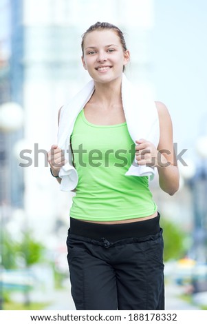 Tired woman after fitness time and exercising in city street park at beautiful summer morning. Sport fitness model caucasian ethnicity training outdoor.