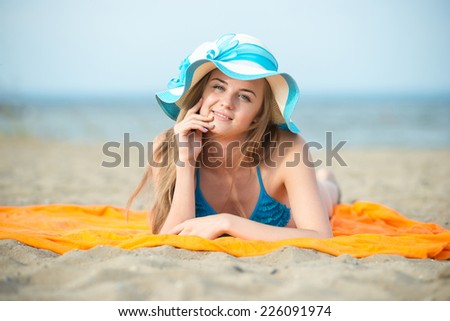 Beautiful woman posing at the summer sand beach. Outdoor summer portrait of pretty sport style woman in blue bikini. Ocean sea coast. Beautiful fit tan girl. slim model caucasian ethnicity outdoors.