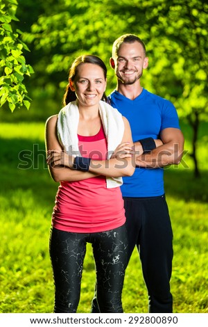 Athletic man and woman after fitness exercise. Beautiful young couple in sports clothing after outdoor exercises. White towel.