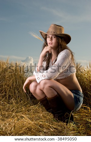 Beautiful slavonic girl in cowboy clothes pose in wheat field