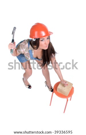 Emotional young woman in orange helmet hammer in nail