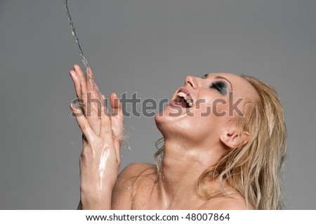Close up portrait of blond woman that play with water