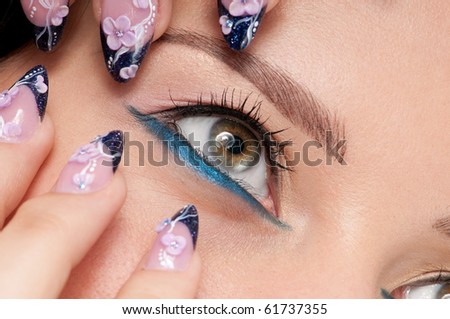 Closeup eyes make-up zone. Nail art. Finger.  Pink and blue color. High resolution.