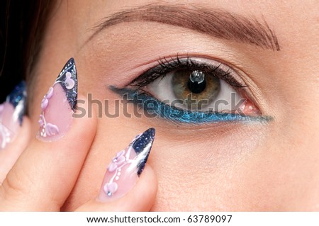 Closeup eyes make-up zone. Nail art. Finger.  Pink and blue color. High resolution.