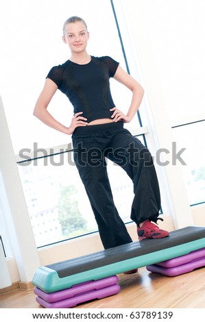 Young woman doing aerobic exercises at the sport gym