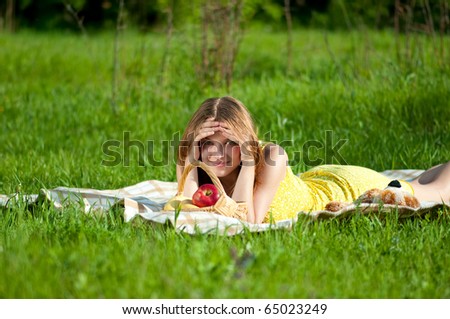 Beautiful young woman on picnic with basket of fruits