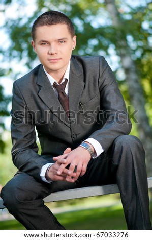 Young business man waiting for meeting at green park. Student.