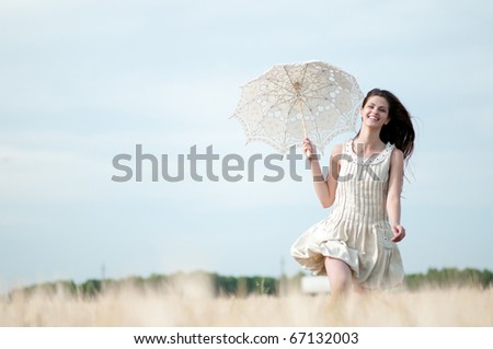 Beautiful sad and lonely woman with umbrella run in wheat field. Timed.