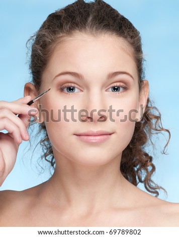 Closeup portrait of young beautiful girl with perfect skin and curly hair. Eye zone shadow make up by brush