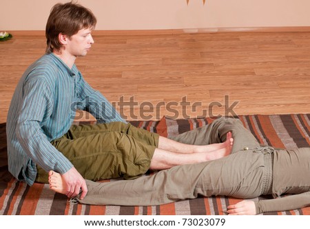 Two young man and woman couple doing yoga. Massage