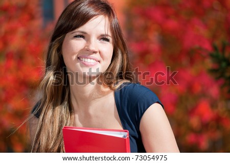 Young beautiful business woman hoding diary at city park. Student