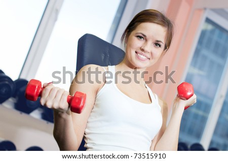 Beautiful sport woman doing power fitness exercise at sport gym. Dumbbell weight!