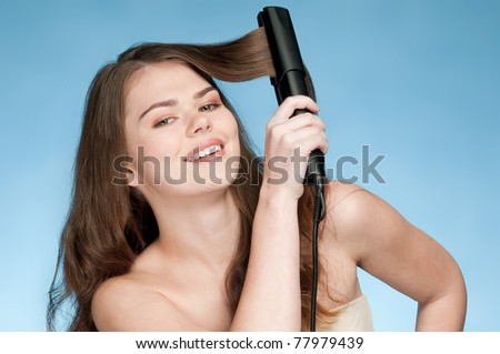 Close up portrait of young beautiful woman that comb perfect hair by iron