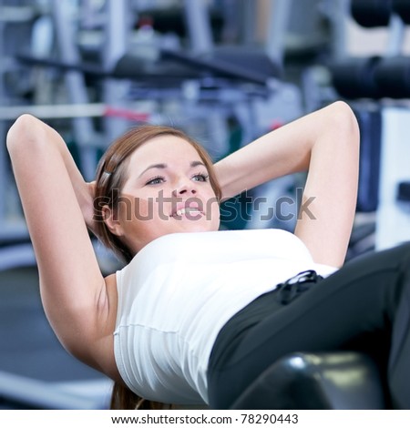 Beautiful sport woman doing press fitness exercise at sport gym