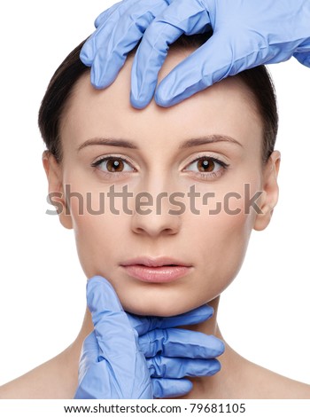 Beautician touch and exam health woman face. Plastic surgery. Isolated