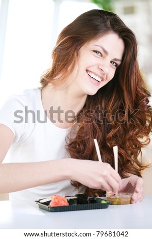 A young attractive woman sitting in a cafe with a sushi