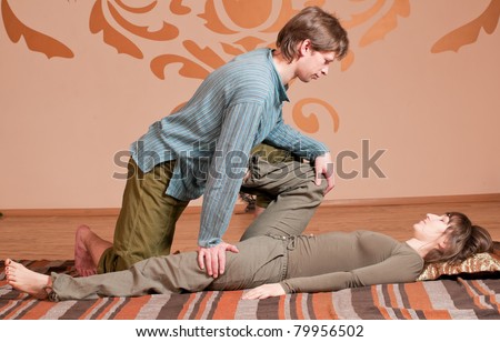 Two young man and woman couple doing yoga. Massage