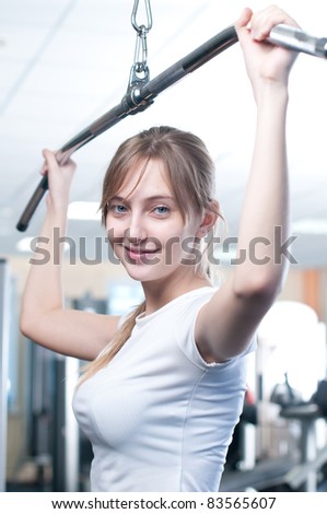 Fitness - powerful casual woman lifting weights in gym club