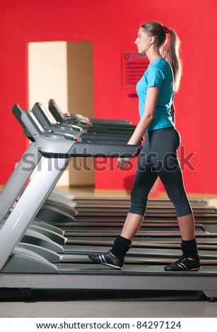 Young woman at the gym exercising. Run on on a machine.