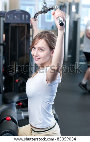 Fitness - powerful casual woman lifting weights in gym club