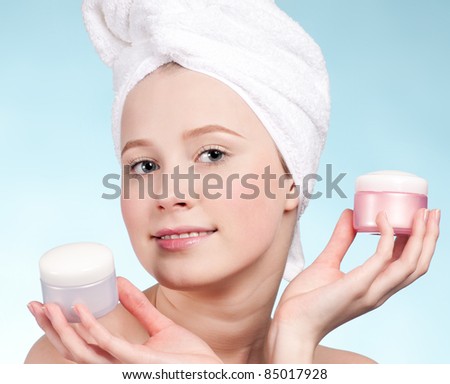 Beautiful woman tender jar of moisturizer cream. Close-up fresh young woman face