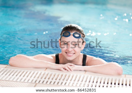 Portrait of a young woman in goggles in swimming pool