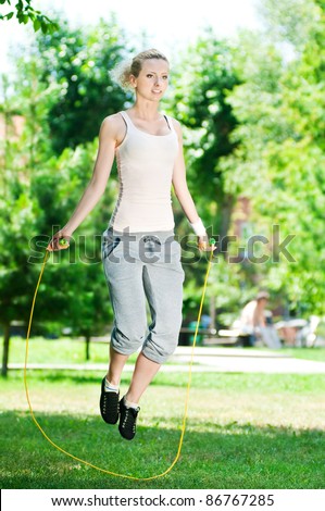 Summer vacation - woman with skipping rope at park