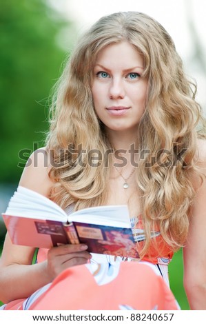 Beautiful young woman read book, at green summer park