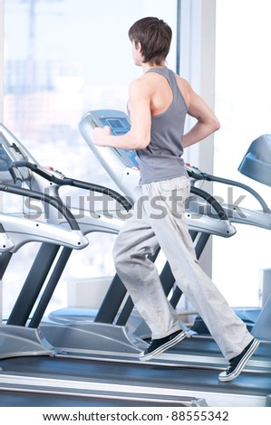 Young man at the gym exercising. Run on on a machine.