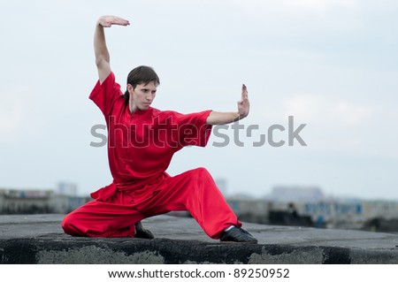 Shaolin warriors wu-shoo man in red practice martial art outdoor. Kung fu