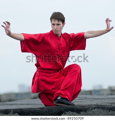 Shaolin warriors wu shoo man in red with sword practice martial art outdoor. Kung fu