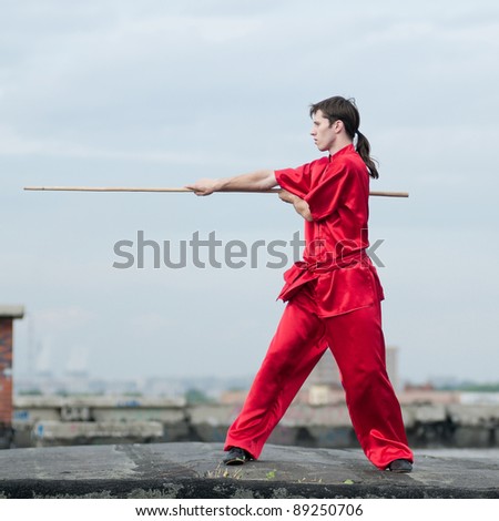 Shaolin warriors wu shoo man in red with sword practice martial art outdoor. Kung fu