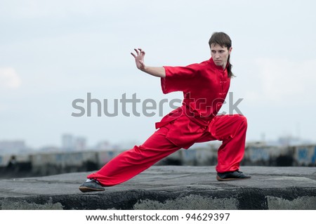 Shaolin warriors wushoo man in red practice martial art outdoor. Kung fu