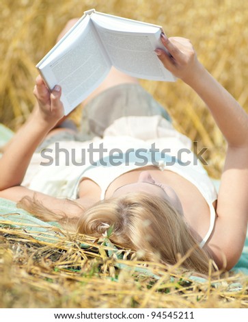 Young happy woman in wheat field. Summer picnic