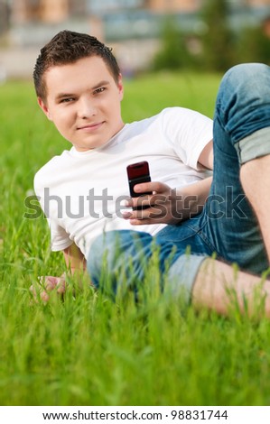 Man on green grass with phone
