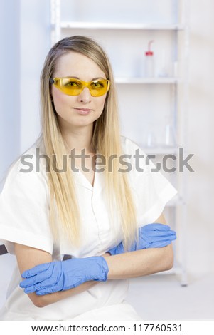 portrait of young woman with protective glasses in laboratory