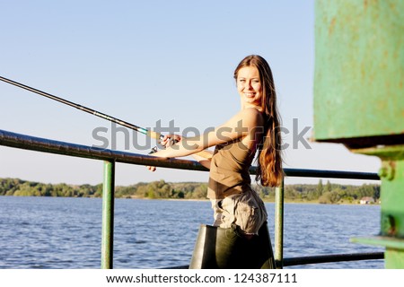 young woman fishing at pond